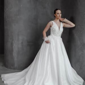 Wedding dress with detachable puffed sleeves, deep V-neckline, lace-up back, and floral appliqués on a flowing satin skirt for a romantic and versatile bridal style.